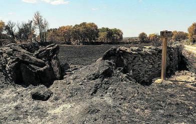 Una pared de piedra y una señal dañadas