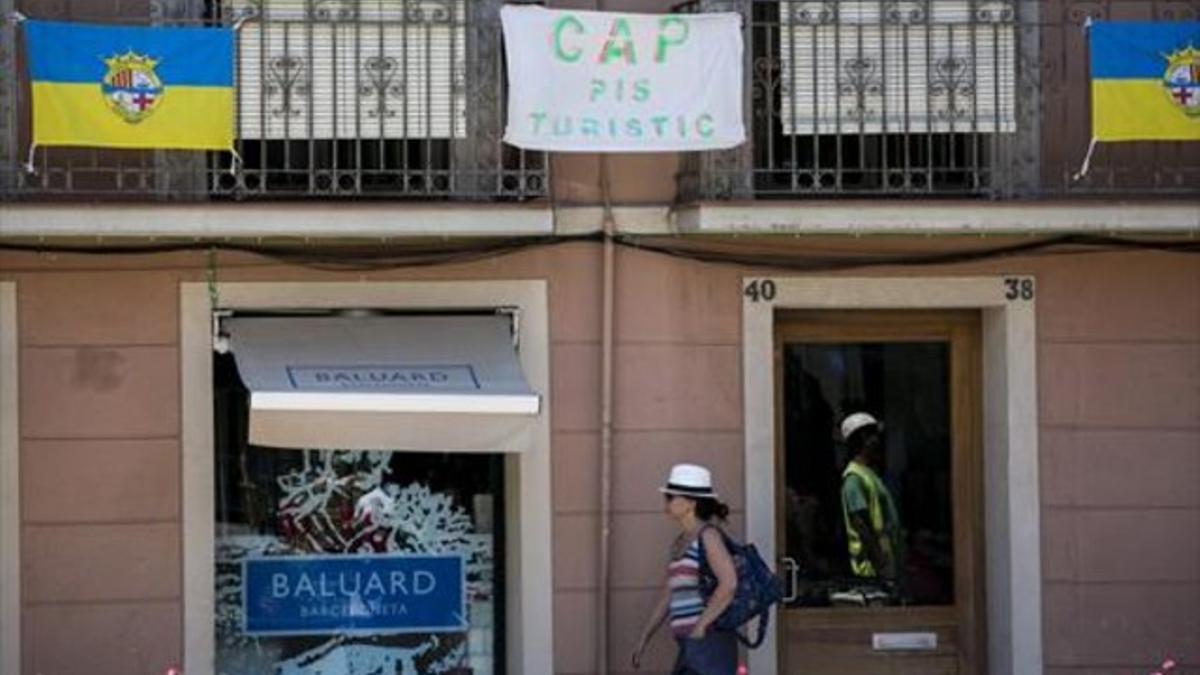 Cartel contra los pisos turísticos en la Barceloneta, uno de los barrios de Barcelona con más apartamentos en alquiler.