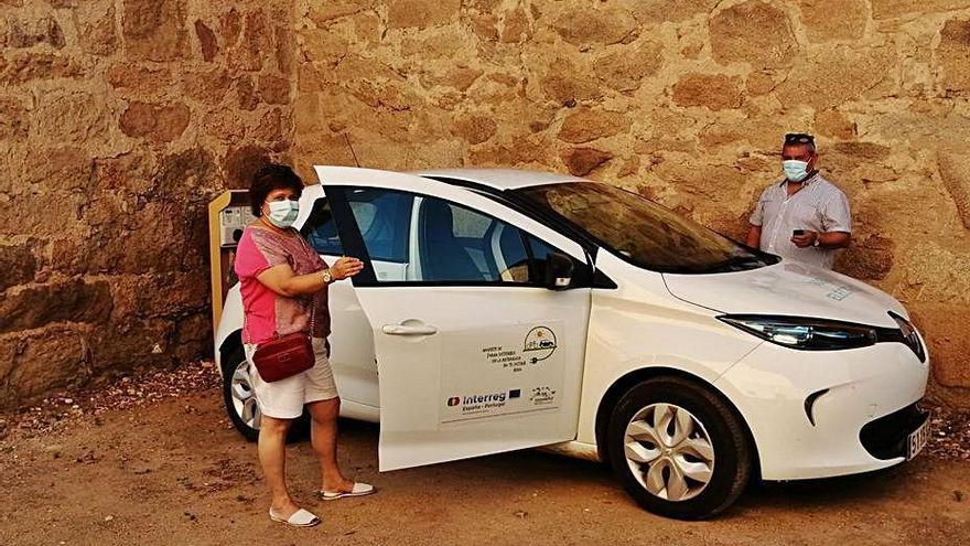 Dos personas recogen el coche eléctrico en la Casa del Parque.