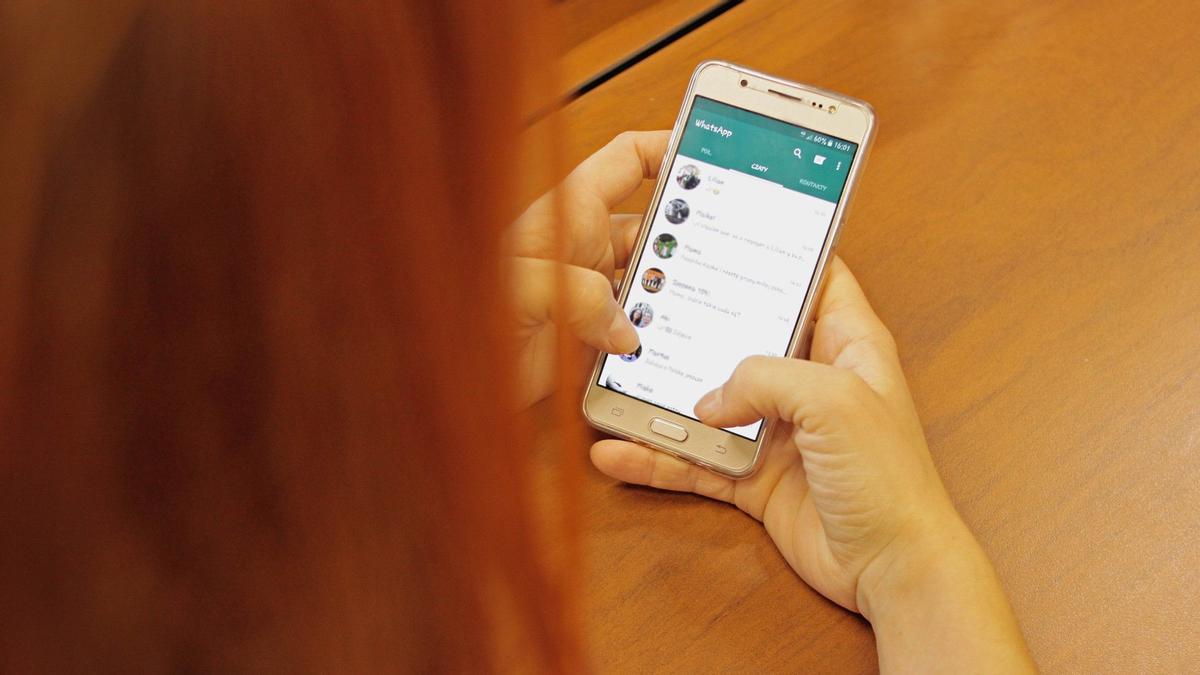 Una mujer consulta sus conversaciones y grupos de Whatsapp