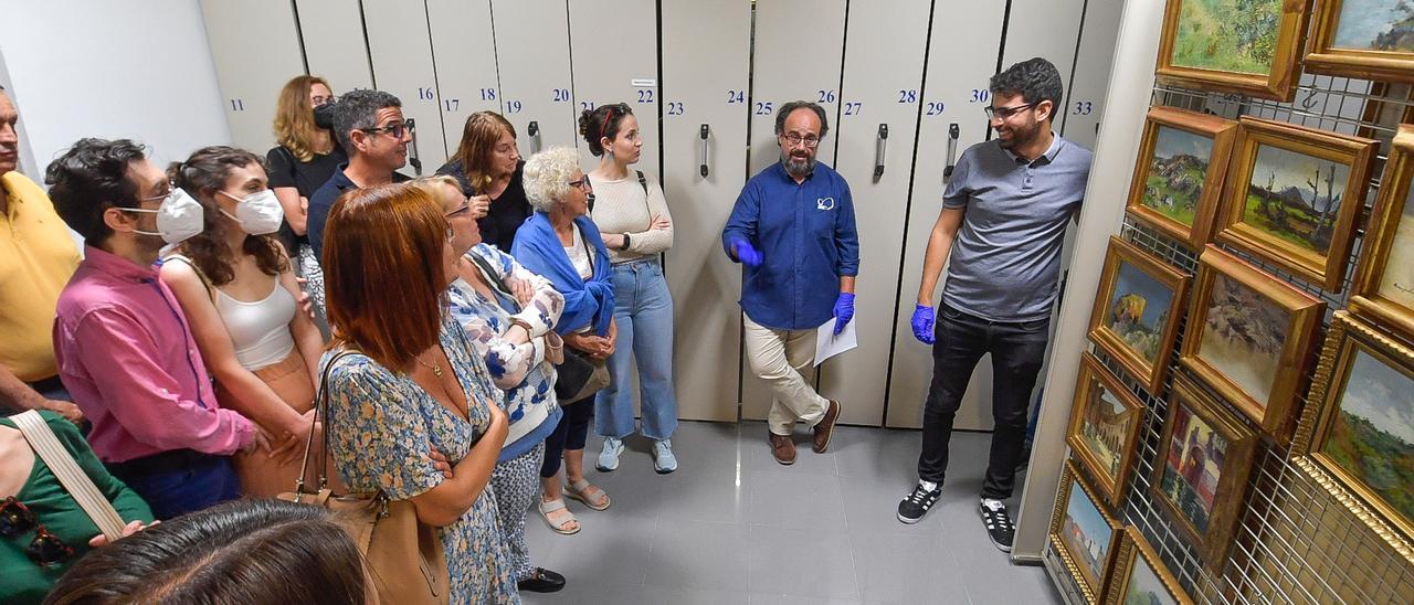 El conservador Jaiver Pueyo explica a los visitantes los peines en los que están depositados las obras de Botas y Ghiralda