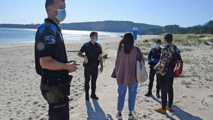 Agentes de la Policía de Cangas, vigilando el entorno de la playa de Nerga ayer por la tarde. // G.Núñez