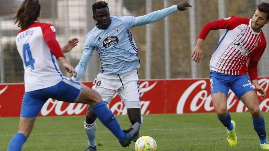 Apeh disputa un balón con dos jugadores gijoneses. // La Nueva España