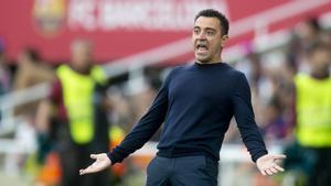 Xavi Hernández sigue el partido desde la banda de Montjuic