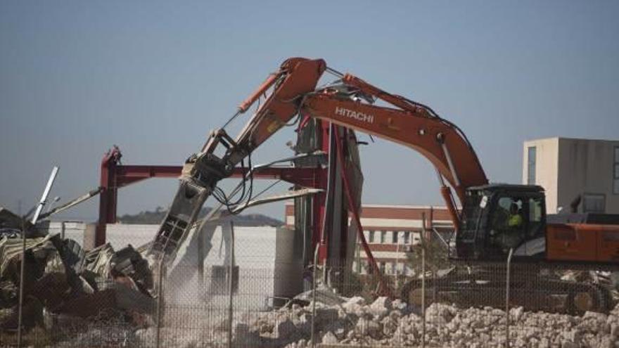 Un excavadora derriba una de las naves de Coca-Cola.