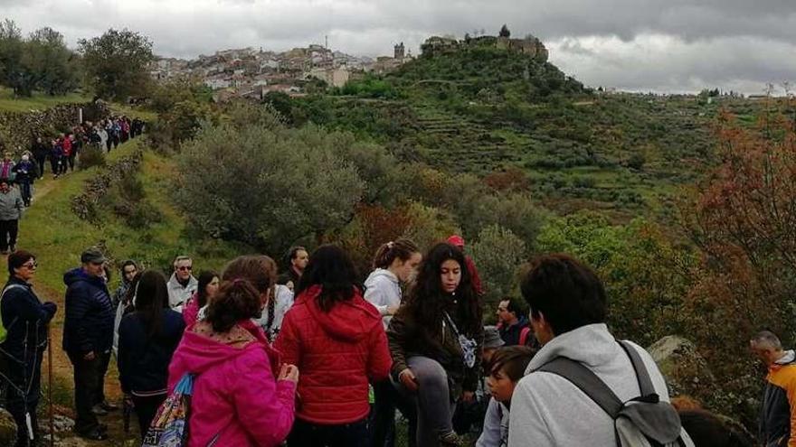 Los senderistas marchan por una senda de Arribes dejando, al fondo, la villa de Fermoselle y el Castillo.