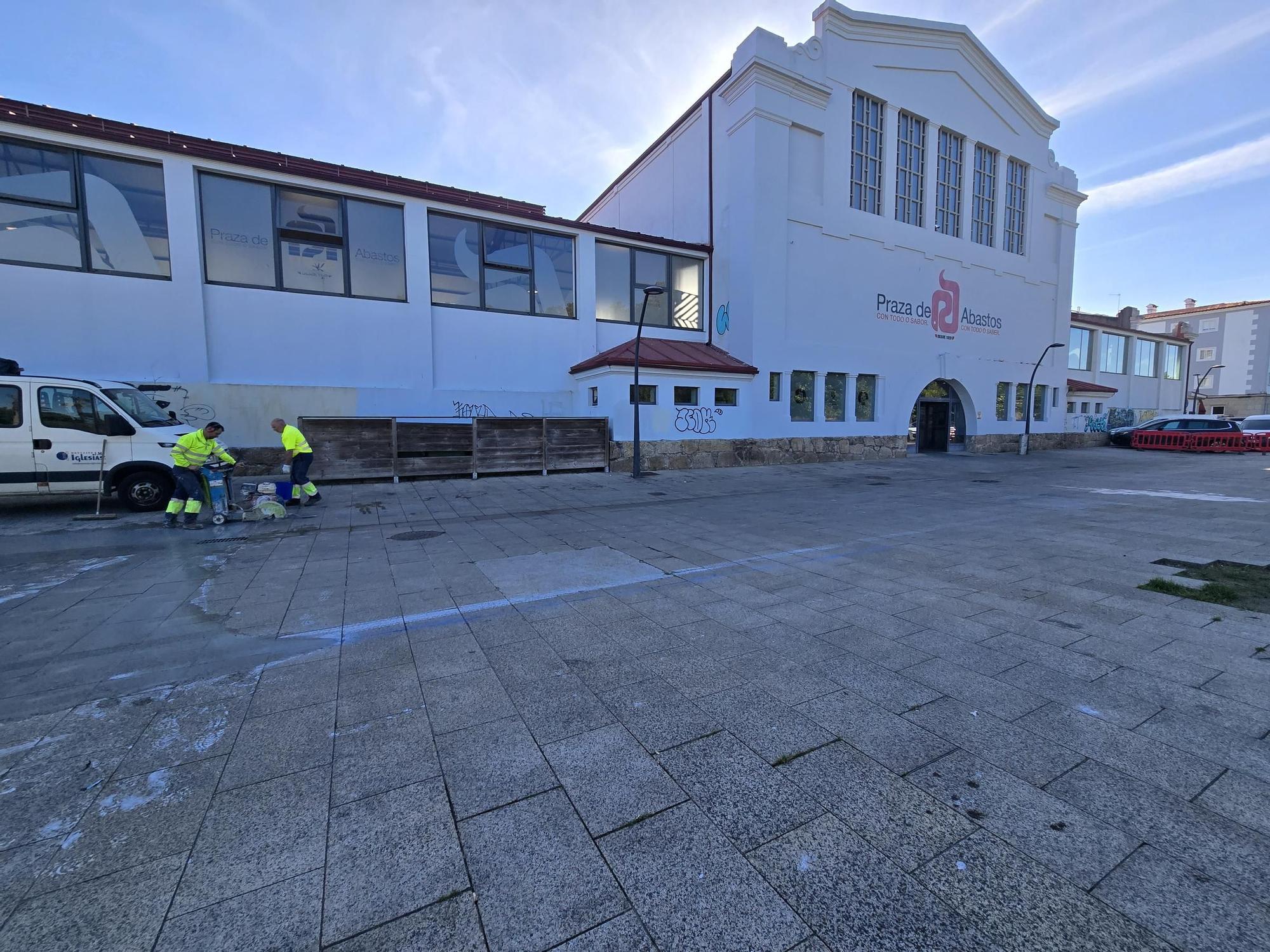 Los operarios eliminan las losas de piedra en el entorno de la plaza de abastos de Vilagarcía para colocar hormigón.