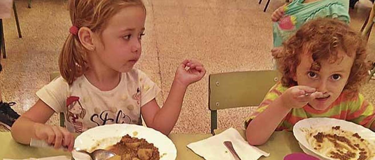 Dos niÃ±os apuran su plato en el comedor del CEIP Molinar.