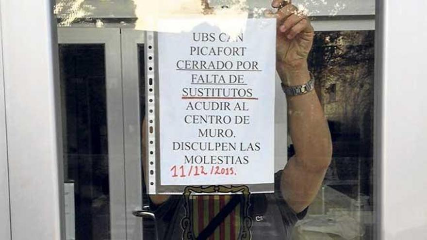 Un empleado coloca el cartel de cerrada en la UBS de Can Picafort.