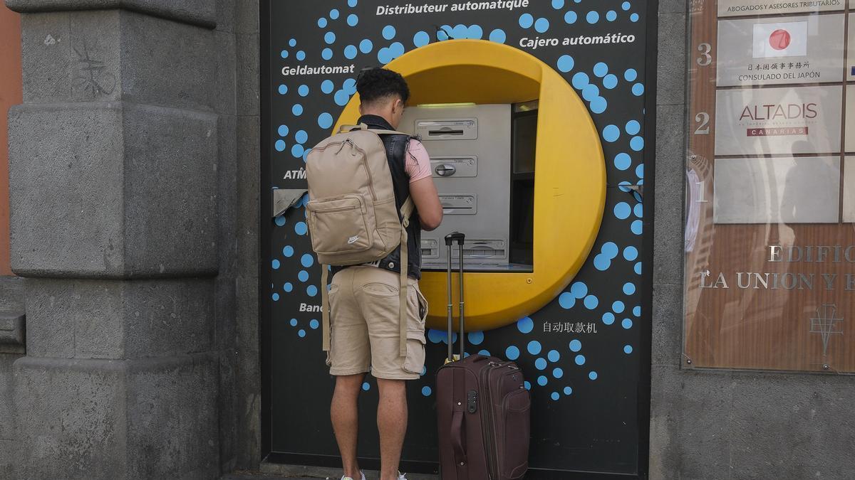 Un jóven en un cajero automático.