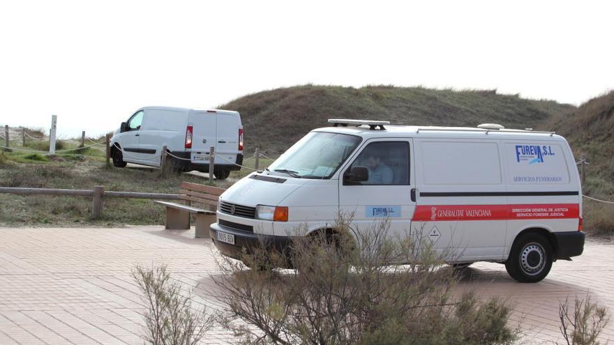 El furgón fúnebre traslada el cadáver de la mujer hallada ayer ahogada en la playa del Saler.