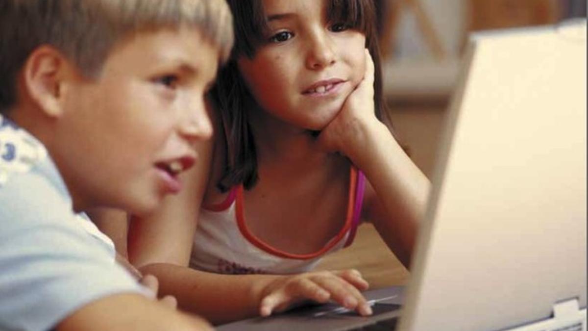 Niños navegando por internet ante un portátil.