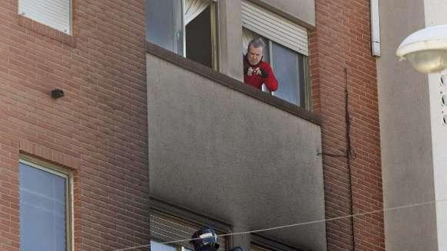 Dos bomberos intentan entrar por la ventana al piso quemado. / morell