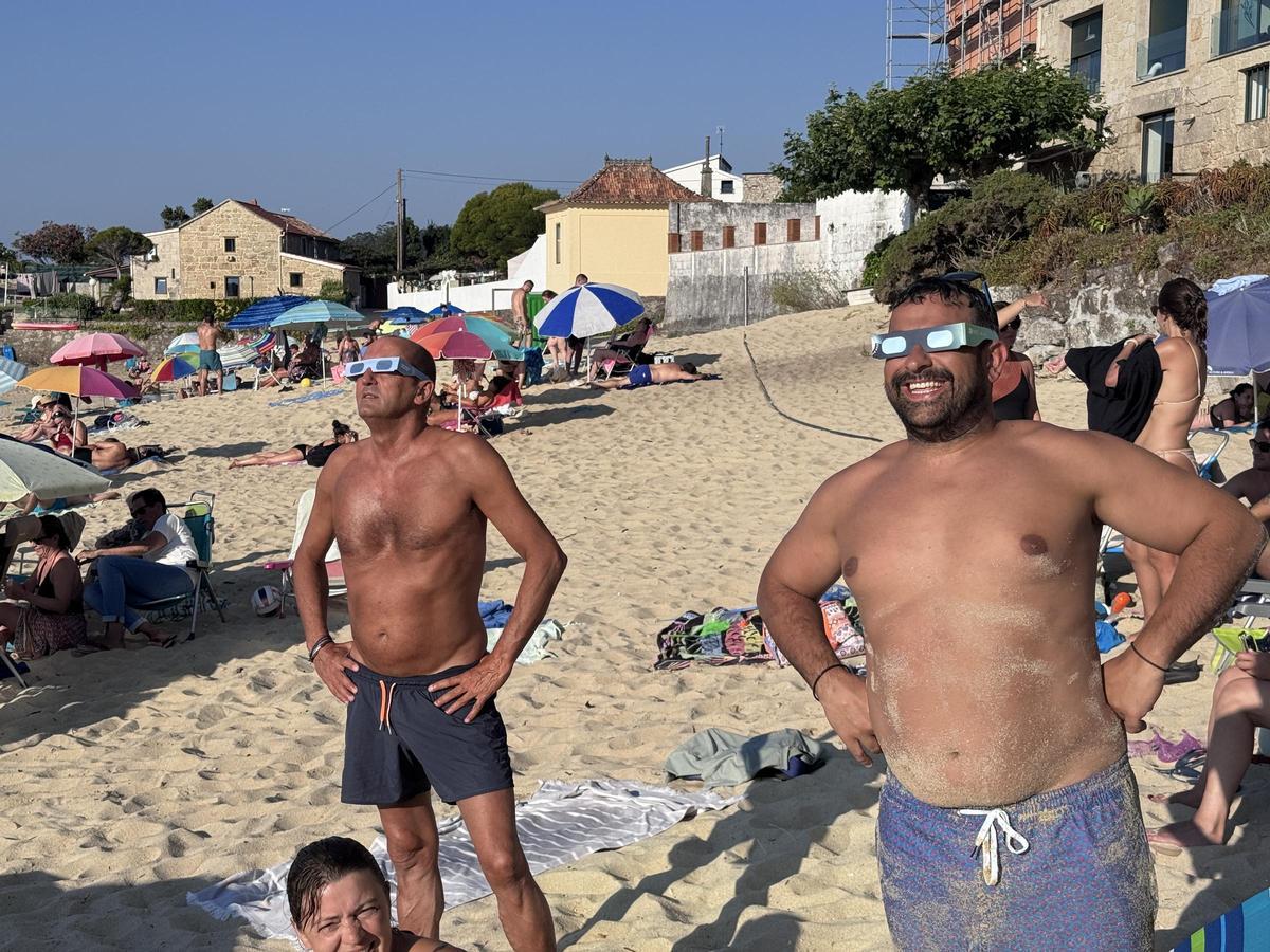 Bañistas y vecinos siguen el eclipse solar desde Loureiro. Bañistas y vecinos siguen el eclipse solar desde Loureiro.