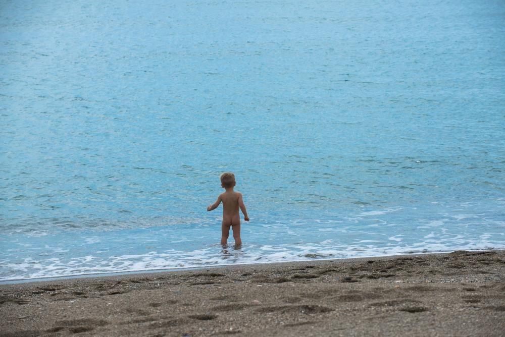 Padres e hijos aprovechan el primer día del desconfinamiento parcial de los niños menores de 14 años para dar un paseo por calles y plazas del Centro de Málaga. En la playa, algunos pequeños aprovechaban para remojarse los pies, bordeando una de las prohibiciones de esta nueva medida.