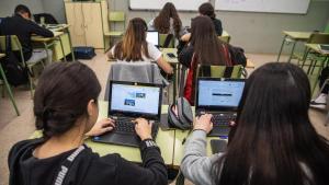 Alumnos de ESO con portátiles y móviles encima del pupitre, el curso pasado en un instituto catalán.