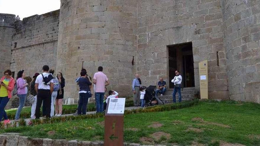 Un grupo de personas a la entrada del Castillo, con una placa de la nueva señalización en primer lugar.