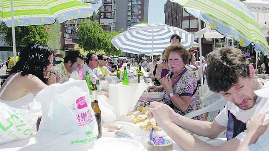 Comensales, ayer, en Villalegre, guarecidos bajo sombrillas para protegerse del sol.