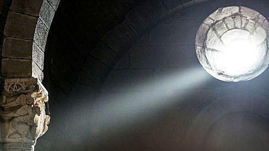 El fenómeno de la luz equinoccial en la iglesia de Santa Marta. La luz del sol entra por el óculo sobre el altar mayor e ilumina el capitel. A la derecha imagen pétrea de Santiago Peregino.