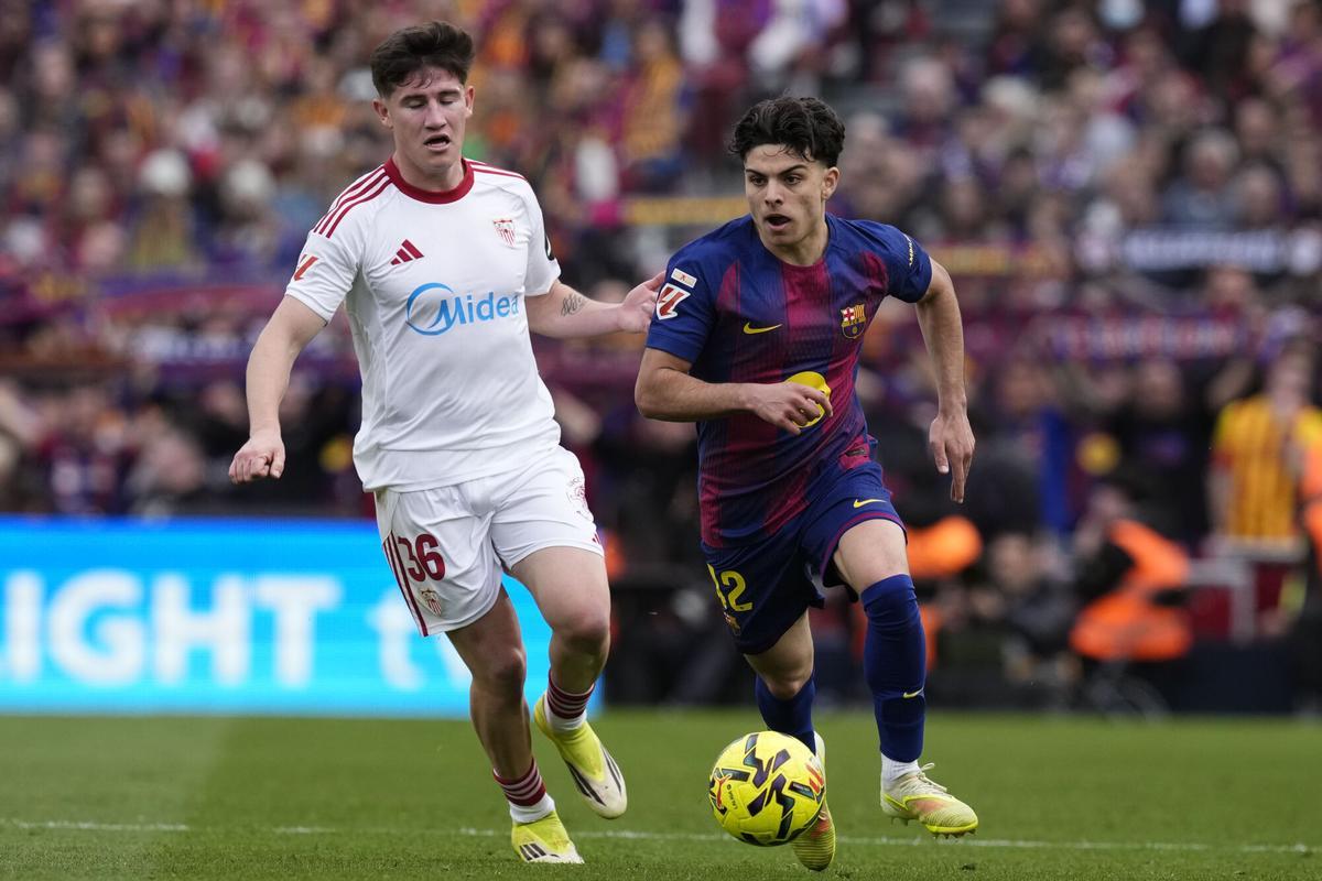 BARCELONA, 15/03/2026.- El lateral del Sevilla Oso (i) ante Xavier Espart , centrocampista del Barcelona, durante el partido de LaLiga entre el Barcelona y el Sevilla disputado en el Camp Nou en Barcelona, este domingo. EFE/ Enric Fontcuberta