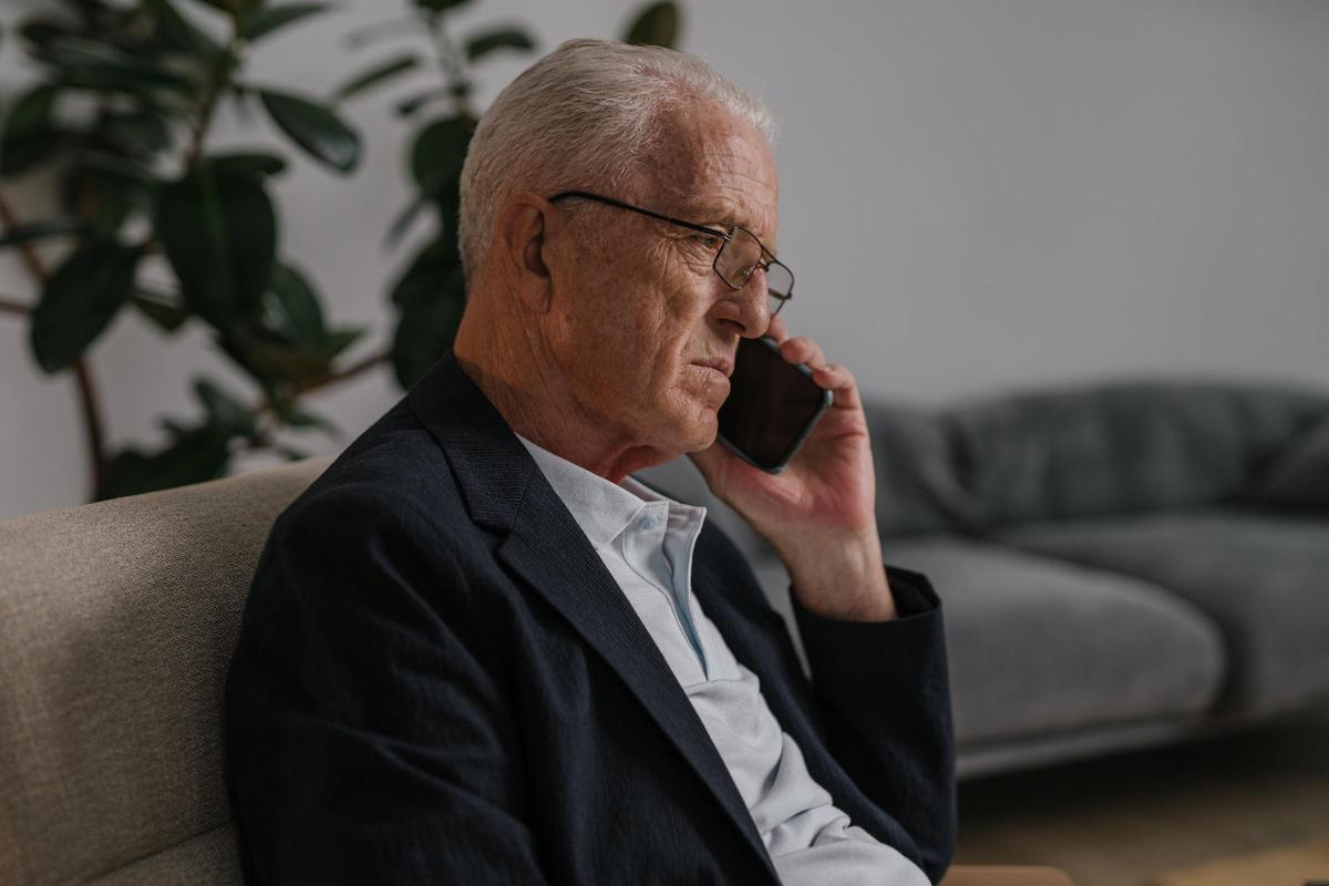 Un hombre mayor hablando por teléfono.