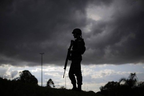 A Brazilian army soldier stands during a security plan drill for the upcoming World Cup soccer tournament along the streets of Brasilia