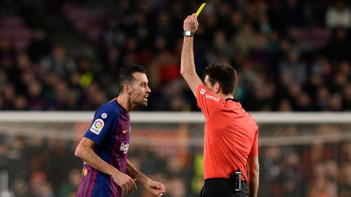 De Burgos Bengoechea, mostrando una tarjeta a Busquets