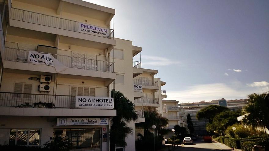 Viviendas de la Colonia Ducal de la playa,
con pancartas contrarias al hotel,
en una imagen de mediodía de ayer
m. p.