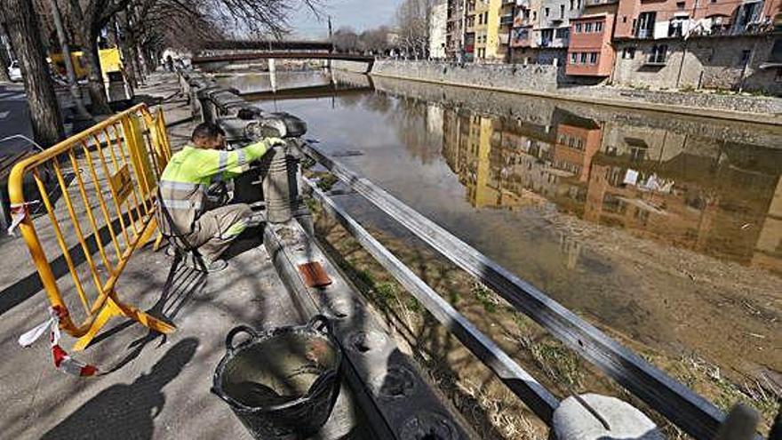 Un operari arreglant el tros de barana.