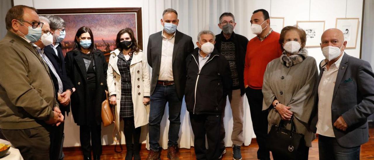 Por la izquierda, Santiago Rodríguez Vega; Rafael Alonso; Alberto Tirador, Yasmina Triguero, Yolanda Alonso; Gerardo González, presidente de la Atlética Avilesina; José Antonio Suárez, “Pepete”; tras él, Pachi Gago; Rafael Rodríguez, jefe de la Policía Local de Avilés; Margarita Cuervo-Arango, y Enrique Rodríguez, Dacal. Arriba, los cuadros de Yago Lamela y Dacal, y sobre estas líneas, asistentes al acto inaugural. | Mara Villamuza