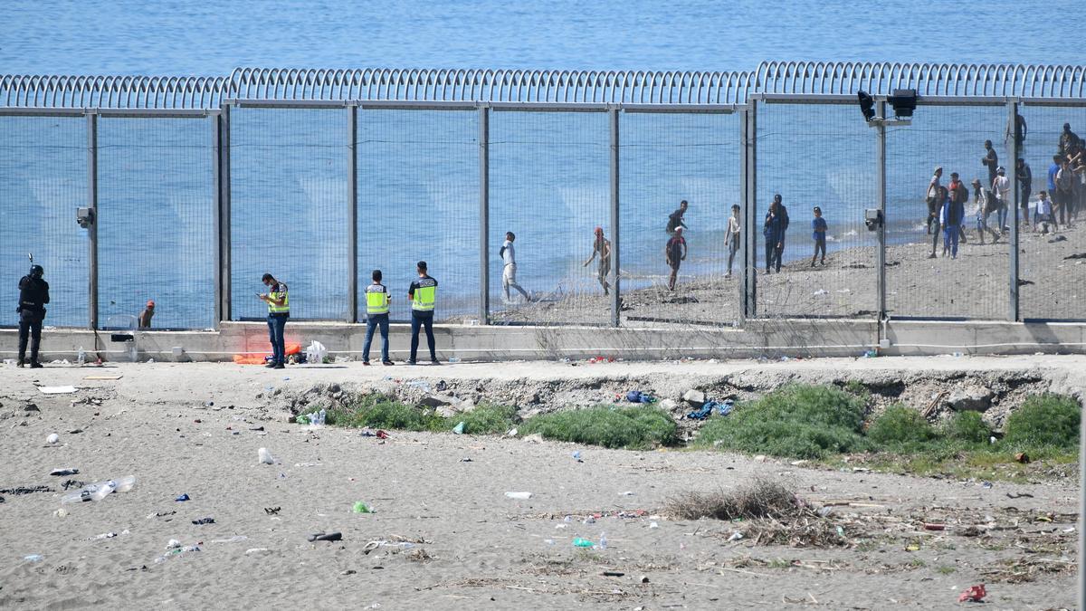 Agentes vigilan la valla que separa Ceuta de Marruecos.