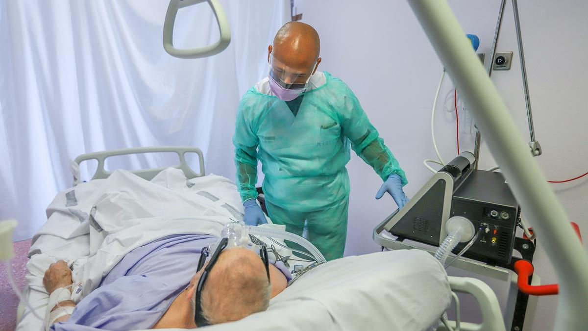 Un médico del Hospital Vega Baja visita a un enfermo en la UCI del centro hospitalario, en una imagen de archivo