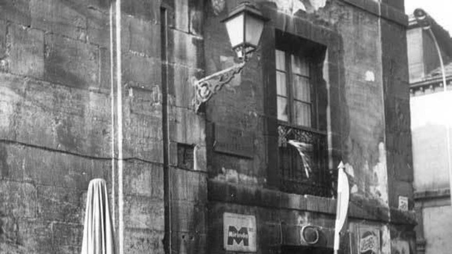 Fotografía de los años sesenta con vendedoras del Fontán apoyadas en el muro del viejo teatro, abandonado hasta que se construyó la Biblioteca de Asturias.