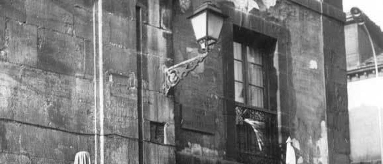 Fotografía de los años sesenta con vendedoras del Fontán apoyadas en el muro del viejo teatro, abandonado hasta que se construyó la Biblioteca de Asturias.