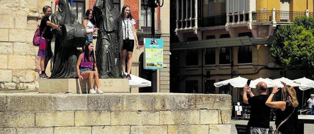 Varias personas se fotografían junto a la estatua del Merlú.