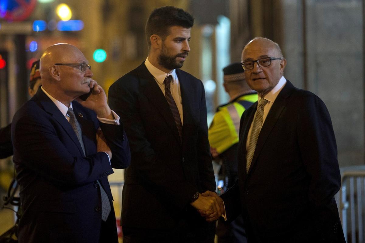 GRAF9517. BARCELONA, 25/02/2018.- El defensa del FC Barcelona Gerard Piqué (c) saluda al presidente del Banco de Sabadell, Josep Oliu (d), en presencia del CEO y consejero delegado del GSMA, John Hoffman (i) tras la cena de bienvenida al Mobile World Congress (MWC), la mayor cita mundial de la tecnología móvil, celebrada esta noche en Barcelona. EFE/Quique García