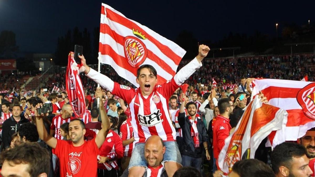 Aficionados del Girona celebrando el ascenso sobre el césped de Montilivi.