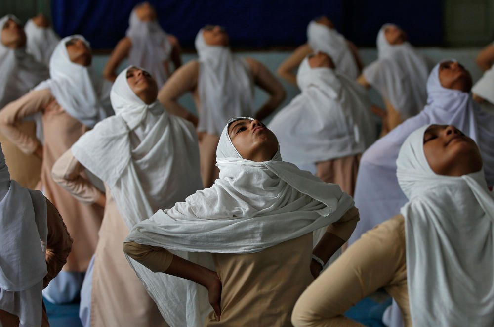 Muslim girls attend a yoga lesson at a school ...