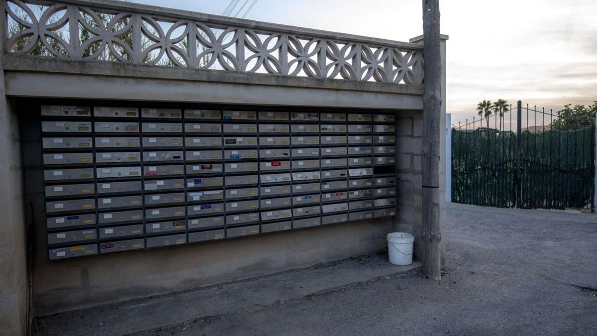 Notificaciones depositadas en una papelera situada junto a un grupo de buzones de una finca. | B.RAMON