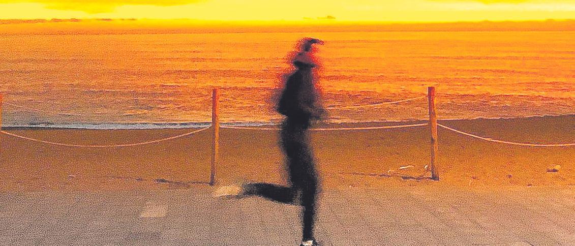 Una mujer hace deporte junto al mar.