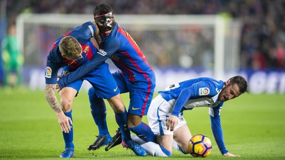 Rafinha y Digne se estorban mientras Tito (Leganés), en el suelo, se lleva el balón.