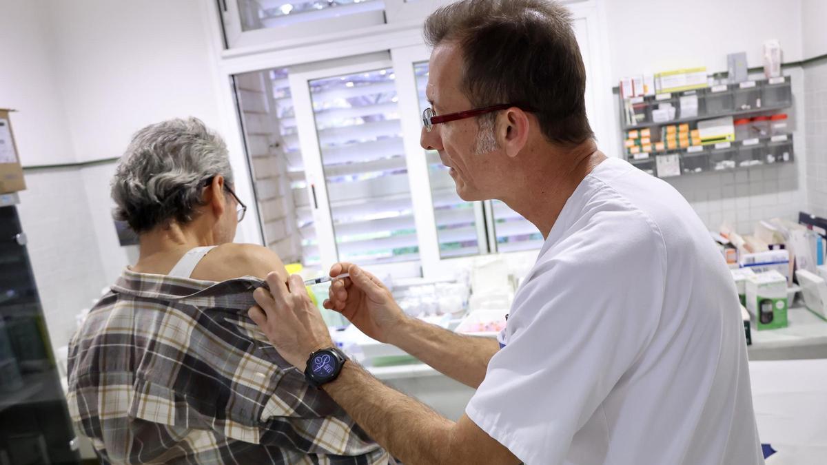 Un sanitario administra una vacuna contra la gripe este invierno.