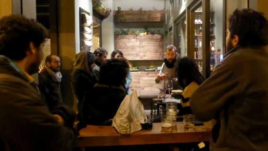 Universitarios de Ergosfera conversan con el responsable del bar La Urbana, en el Ensanche. / la opinión