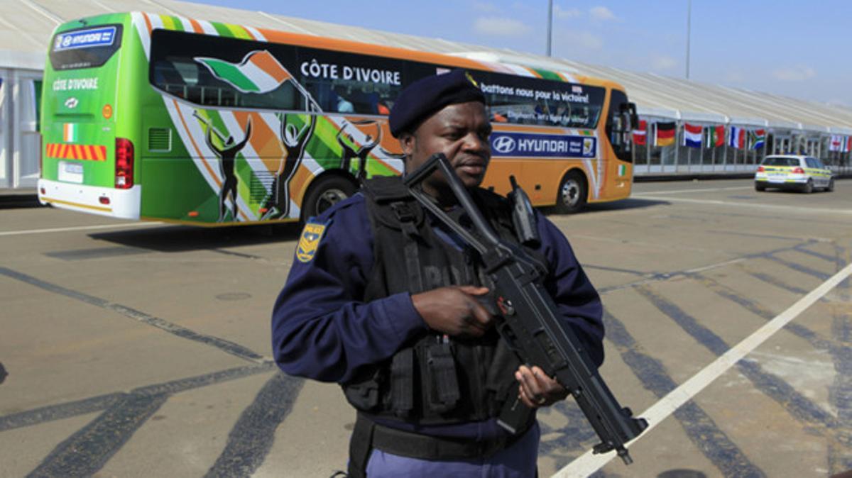 Un policia guarda l’autocar de la selecció de Costa d’Ivori després de la seva arribada a l’aeroport de Johannesburg.