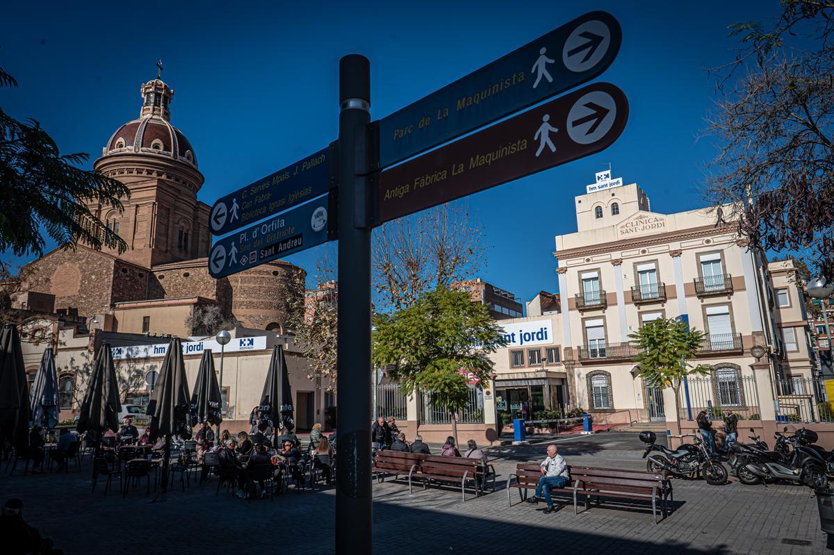 Plaza de la Estación, cuna del Sant Andreu histórico, con terrazas, la parte posterior de la parroquia y la clínica Sant Jordi