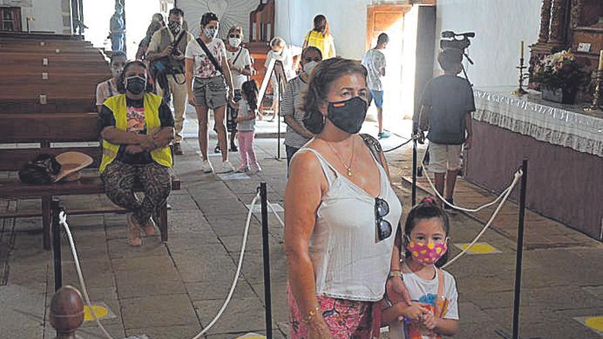 Una mujer y su hija ante el altar de la Virgen.