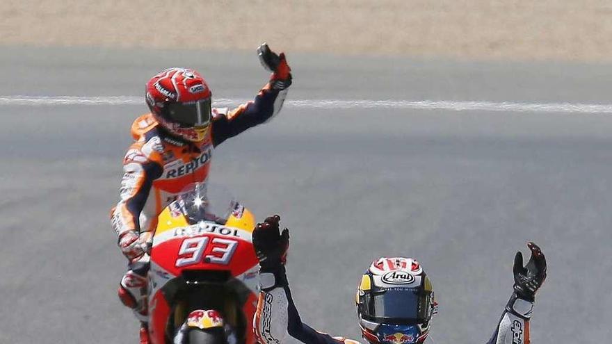 Dani Pedrosa alza las manos para celebrar su victoria en Jerez mientras Márquez saluda al público.