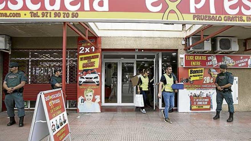 Agentes de la Guardia Civil, ayer, durante el registro de la autoescuela en la calle Aragó. guillem bosch