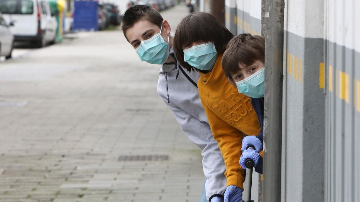 Un grupo de niños se asoman a una calle de Santiago. // Xoán Álvarez