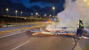 Un bommbero sofoca una barricada en uno de los accesos a Cádiz por la huelga del metal.
